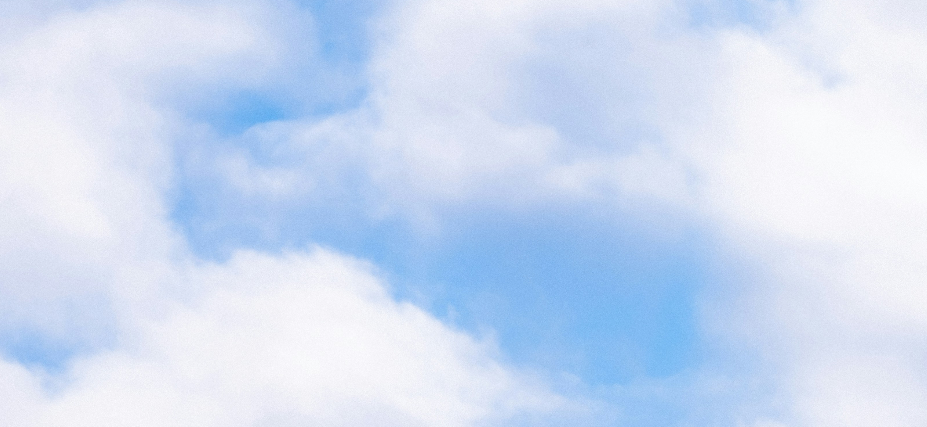 Soft blue sky with white clouds representing calm and mindfulness.