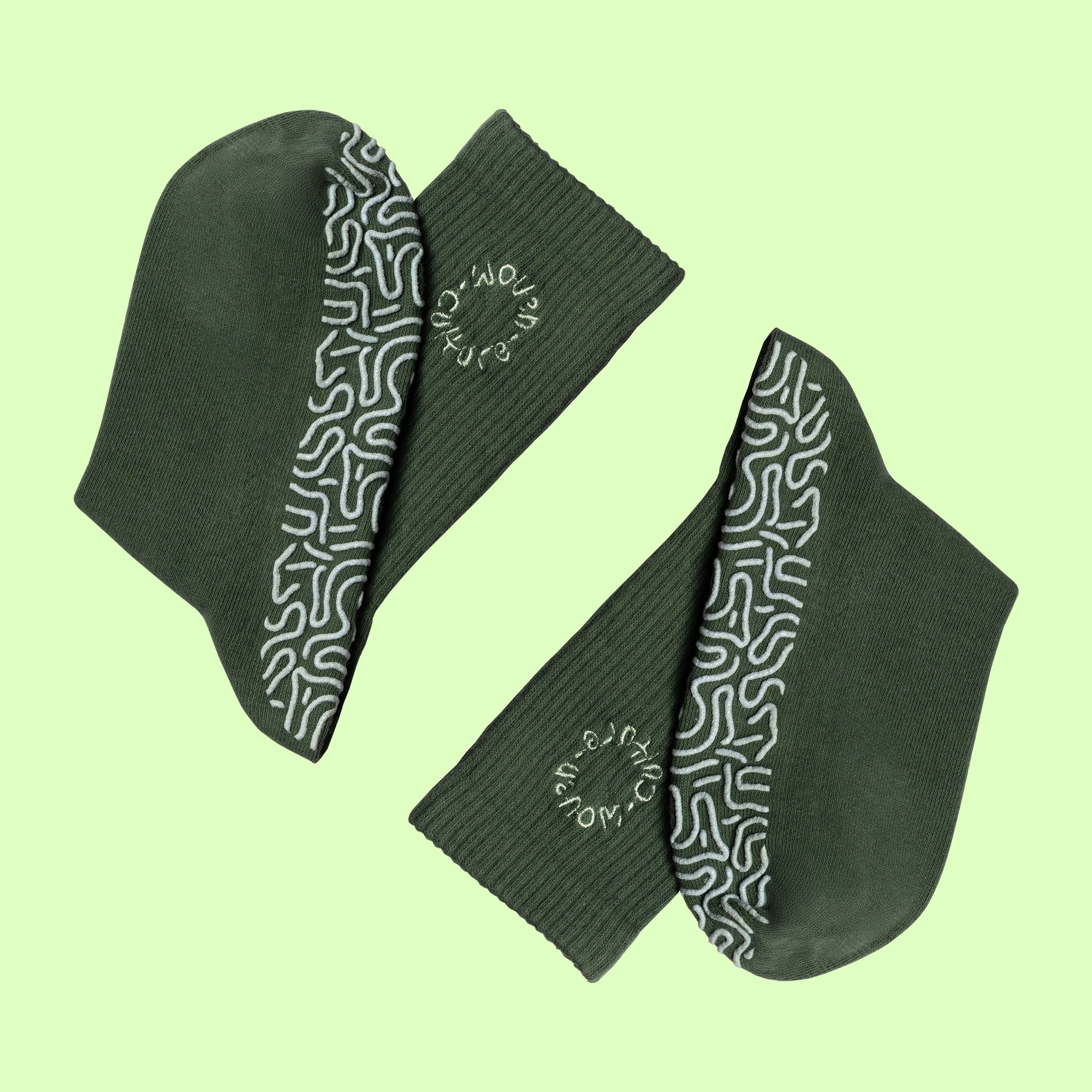 Green organic cotton grip socks with non-slip sole pattern and Woven Culture logo, eco-friendly Pilates and yoga socks.